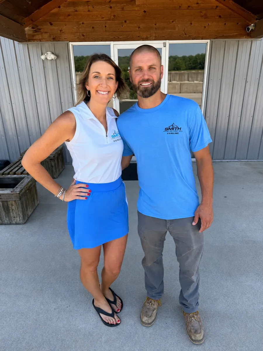 Owners Brandon and Brooke Smith standing together in branded Smith Heating apparel